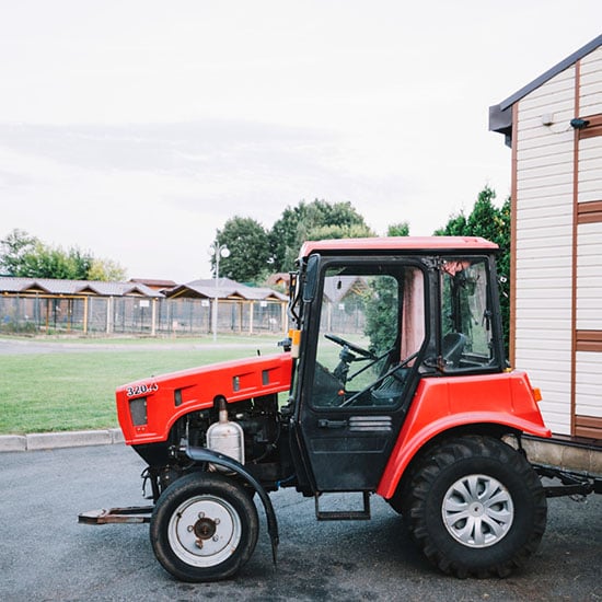 Close up image of a red tractor in a field
