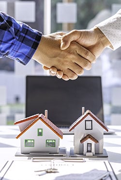 Real estate agents and clients shake hands Real estate agents and clients shake hands