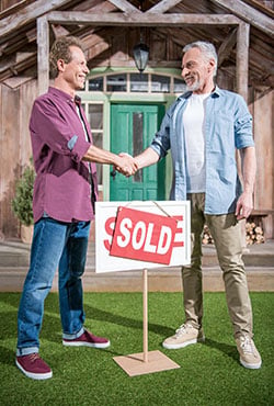 Real estate agents and clients shake hands